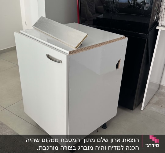 ארון לבן עם ידית מתכת על רצפה אפורה